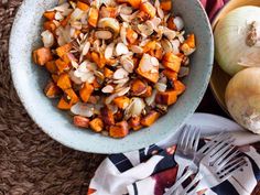 a bowl filled with chopped up vegetables next to a knife and fork