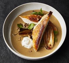 a white bowl filled with food on top of a table