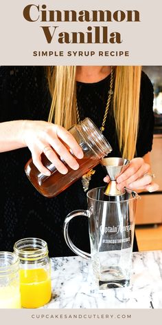 a woman pours some liquid into a glass pitcher on a counter top next to two mason jars