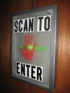 a sign that says scan to enter with a hand print on the back of it