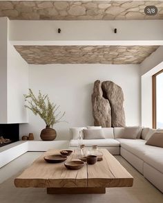 a living room with a couch, table and large stone sculpture in the corner on the wall