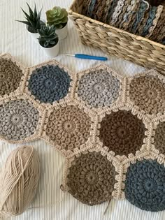 a crocheted rug and yarn next to a basket