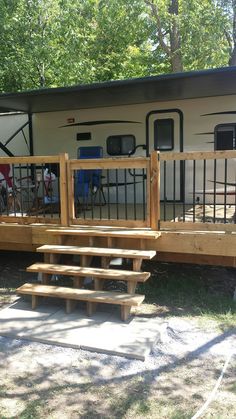 a small trailer with stairs leading up to the front door and back porch area, next to a picnic table