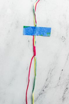 a piece of paper that has been made to look like a cross with colored yarn on it