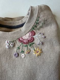 an embroidered sweater with flowers on it