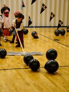 children playing with black balls in an indoor gym