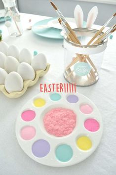 an easter table setting with painted eggs and utensils