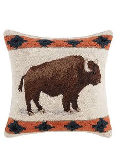 an embroidered bison pillow is shown on a white background with blue, orange and brown flowers