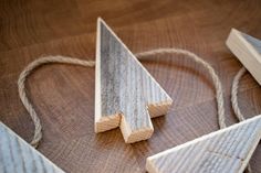 three pieces of wood sitting on top of a wooden table next to twine strings