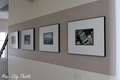 three framed photographs hang on the wall next to a stair case in a home's entryway