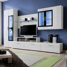 a living room filled with furniture and a flat screen tv on top of a white entertainment center