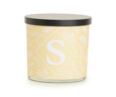 a candle with the letter s on it and a black lid in front of a white background