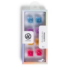 four different colored cubes in a box with labels on the front and back side