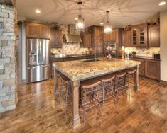 a large kitchen with wooden floors and granite counter tops, along with stainless steel appliances