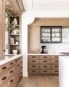 a kitchen with wooden cabinets and marble counter tops