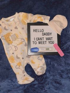 a baby's pajamas and sign that says hello daddy i can't wait to meet you