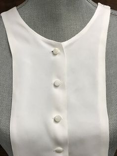 "A lovely vintage off white collar with a 6 button front closure. Buttons are mother of pearl shank style. Cute collar to sew under a sweater. Total length 18.75\" Front neck to bottom hem 15\" Width in center 6\" Shoulder to shoulder 8\" It is in good vintage condition. When unbuttoned there a few pulls around the button hole but these do not show when the collar is button. Please visit my shop to view my entire vintage selection at CobbledStreets: https://www.etsy.com/shop/CobbledStreets?ref=h Classic Fitted Blouse With Pearl Buttons, White Formal Blouse With Button Closure, Classic Formal Blouse With Pearl Buttons, Formal Blouse With Pearl Buttons, Classic Blouse With Collar And Buttons, Classic White Blouse With Pearl Buttons, Classic White Buttoned Blouse, Classic Blouse With Pearl Buttons, Classic White Blouse With Buttons