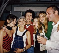 a group of young people standing next to each other in front of a building at night