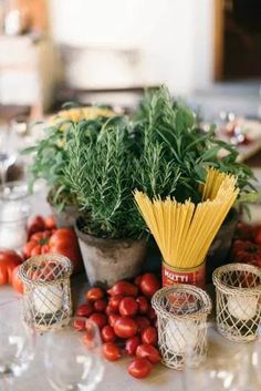 a table topped with lots of different types of food next to wine glasses and candles