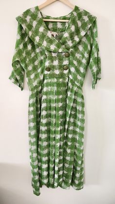 "Look at this charming, cheerful spring-ready day dress by Spector and Shanler of New York. The fabric is a lovely green print in a very lightweight - almost gauze, with a deep shawl collar and two rows of buttons. Color is maybe a little more olive than it appears in pics. Fit and flare, looks like it used to have a belt, but that has gone missing sometime in the last 60-70 years, unfortunately. It's in remarkable shape otherwise, though. The hem is very deep, which gives it a bit of weight and swingy-ness.  Tag Sizing: None Measurements: Armpit to armpit: 17.5\" Shoulder to shoulder: 17\" Sleeve: 13.5\" Back from base of collar: 16.5\" to waist Skirt: 26\" How we measure: with garment laid flat, we measure straight across at the listed areas. Size conventions differ with era, so please t Green Short Sleeve Vintage Dress For Spring, Green Retro Vintage Dress With Short Sleeves, 1950s Style Green Vintage Dress For Spring, 1950s Green Short-sleeved Dress, 1950s Green Short Sleeve Dress, 1950s Style Green Short Sleeve Dress, Fitted Green Vintage Dress For Spring, 1950s Style Green Dress For Garden Party, Vintage Green Dress For Garden Party