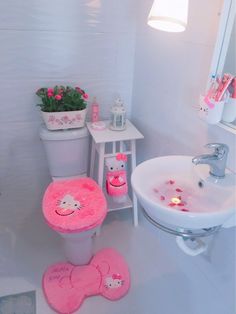 a bathroom with hello kitty rugs and flower pots