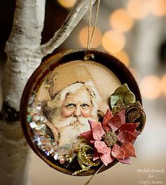 a christmas ornament hanging from a tree with a santa clause face on it