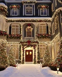 a house covered in christmas lights and garlands with wreaths on the front door