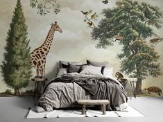 a giraffe is standing in front of a wall mural with birds and trees