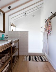 a bathroom with white walls and wooden floors