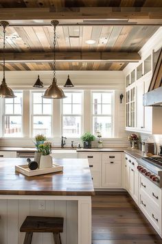 a large kitchen with wooden floors and white cabinetry, along with an island in the middle