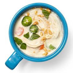 a blue bowl filled with soup and vegetables