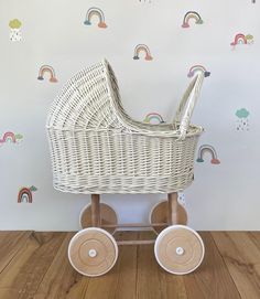 a white wicker baby carriage with rainbows and clouds on the wall behind it