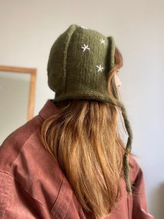 a woman with long hair wearing a green hat