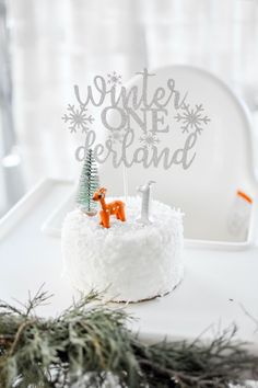 a white cake topped with frosting and an orange deer figurine sitting on top of it