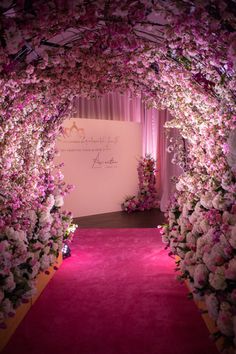 the entrance to a wedding ceremony with pink carpet and flowers on either side of the aisle