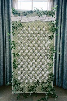 a green and white quilted wall hanging in front of a window