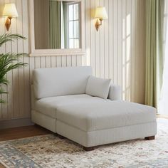 a living room with a white couch and mirror