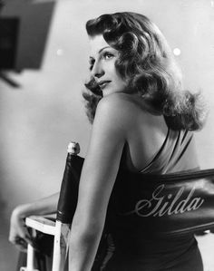 a black and white photo of a woman sitting in a chair