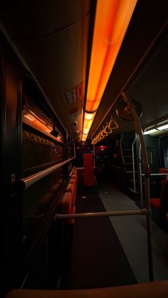 the interior of a train with red seats and yellow lights on it's ceiling