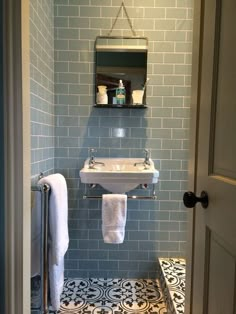 a white sink sitting under a bathroom mirror next to a towel dispenser