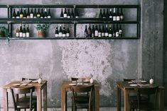 two tables and chairs with bottles on the wall