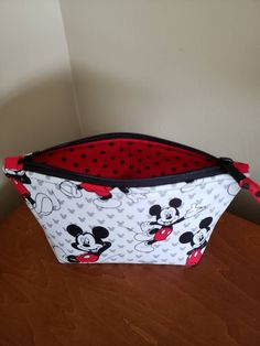 This Mickey Mouse themed pouch is perfect for Mickey Mouse lovers. A great pouch for make up when traveling. Just the right size for personal items or inside a large tote or purse to keep small items from falling to the bottom. I love to carry numerous pouches like this in my tote to keep everthing handy. Would also make a cute bag for a young girl. The outside fabric has a white background with gray Mickey Mouse heads. The traditional Mickey Mouse figure is black, white, and red. The fabric is Mickey Mouse Head, Red Polka Dot, White And Red, The Pouch, Black Polka Dot, Cute Bag, Cosmetic Bags, A White Background, Large Tote