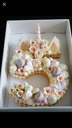 a birthday cake in a box decorated with flowers and unicorn ears