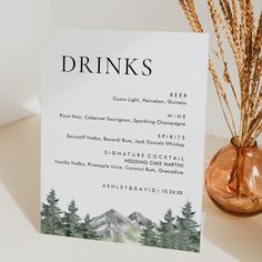 a drink menu sitting on top of a table next to a vase