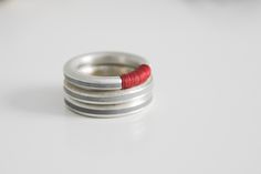 "This contemporary modern ring is made from sterling silver, cast with a polymer concrete inlay and Wrapped with red nylon threads. The clean Minimalist design makes this unique and timeless piece and it looks great alone or stacking. Ring width 0.14' / 3mm Listing is for ONE ring. S I Z I N G Need a different size / color ? Please use the drop down menu on the upper right-hand side of this page to see the rest of the options and make your selection. If you can not find the right size or color, Concrete Inlay, Minimalist Silver Ring, Cube Necklace, Red Ring, Red Rings, Silver Cleaner, Contemporary Ring, Ring Stacking, Midi Rings