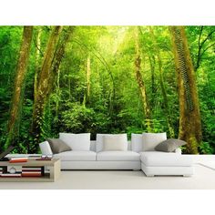 a living room filled with furniture and lots of green trees on the wall behind it