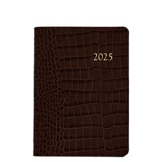 a brown alligator skin notebook with the year 2013 written in gold on it's cover