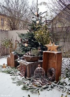 a small christmas tree is surrounded by old suitcases and other decorations in the snow