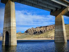 a bridge over water with mountains in the background