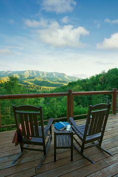 two wooden chairs sitting on top of a wooden deck